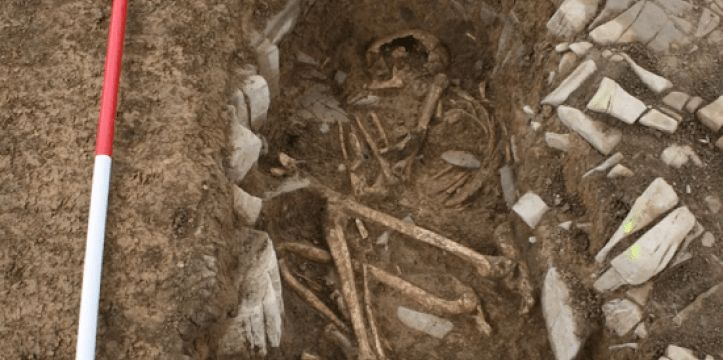 Een van de ineengekropen skeletten in een graf omlijnd met stenen