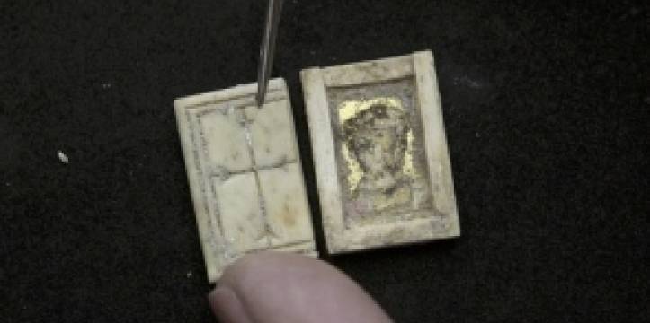 Het doosje, met links het kruis en rechts een portret. Beeld: Associated Press Volgens archeologen is het Christelijk relikwie een belangrijke vondst.