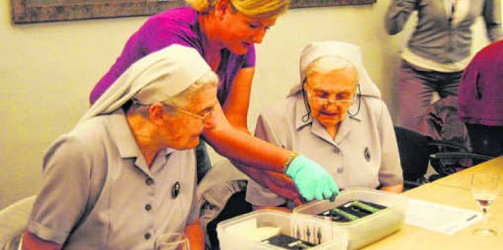 De zusters van het klooster bekijken de gevonden voorwerpen. (Beeld: Inge Bosschaerts) Zusters van het passionistenklooster