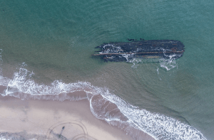 Een dronefoto van het mysterieuze wrak voor de kust.