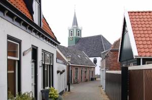 Straatje in Oudeschild met op de achtergrond het witte Zeemanskerkje.