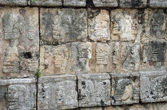 Beeltenissen van doodshoofden op een muur in Chichén Itzá.