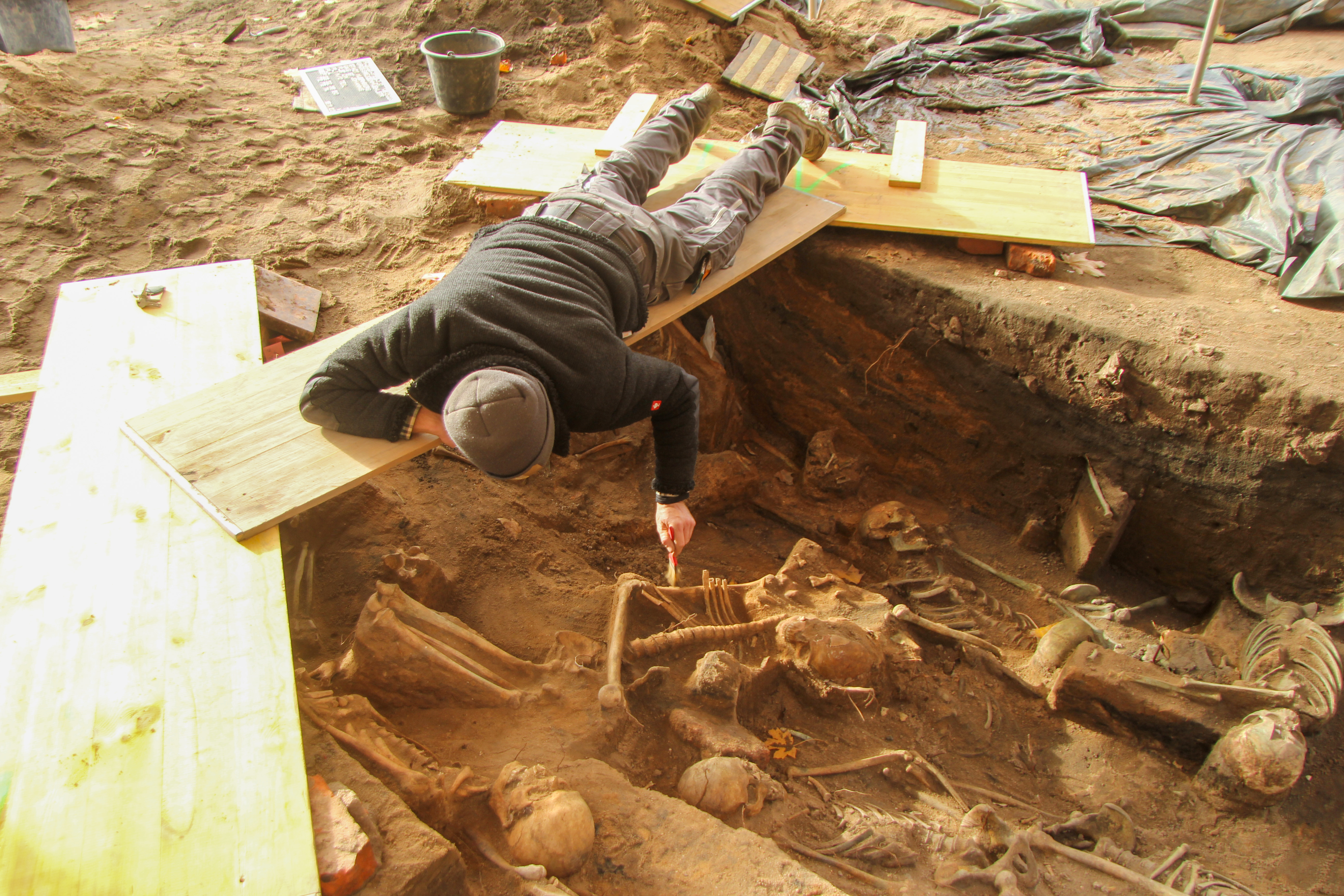 Doordat de skeletten dicht op elkaar zijn begraven moesten de archeologen de opgraving vanaf een geïmproviseerde brug boven de grafkuilen uitvoeren. 