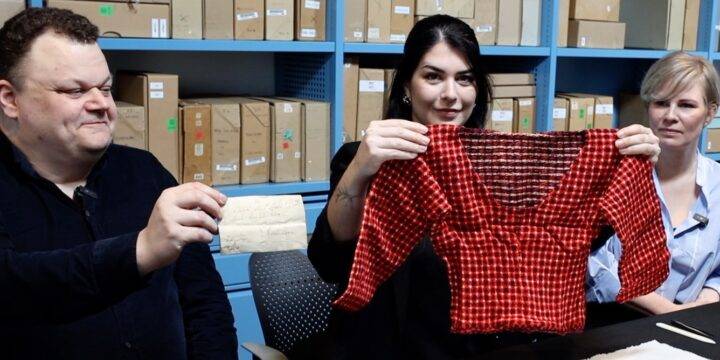 Onderzoekers houden de trui omhoog die ze vonden tussen onbezorgde post uit 1807.         